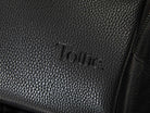A black leather travel backpack with black zippers and has Tottie marking on it