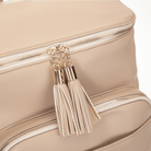Stone travel backpack with tassel details on a white background