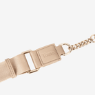Beige belt bag's strap with gold buckle on a white background