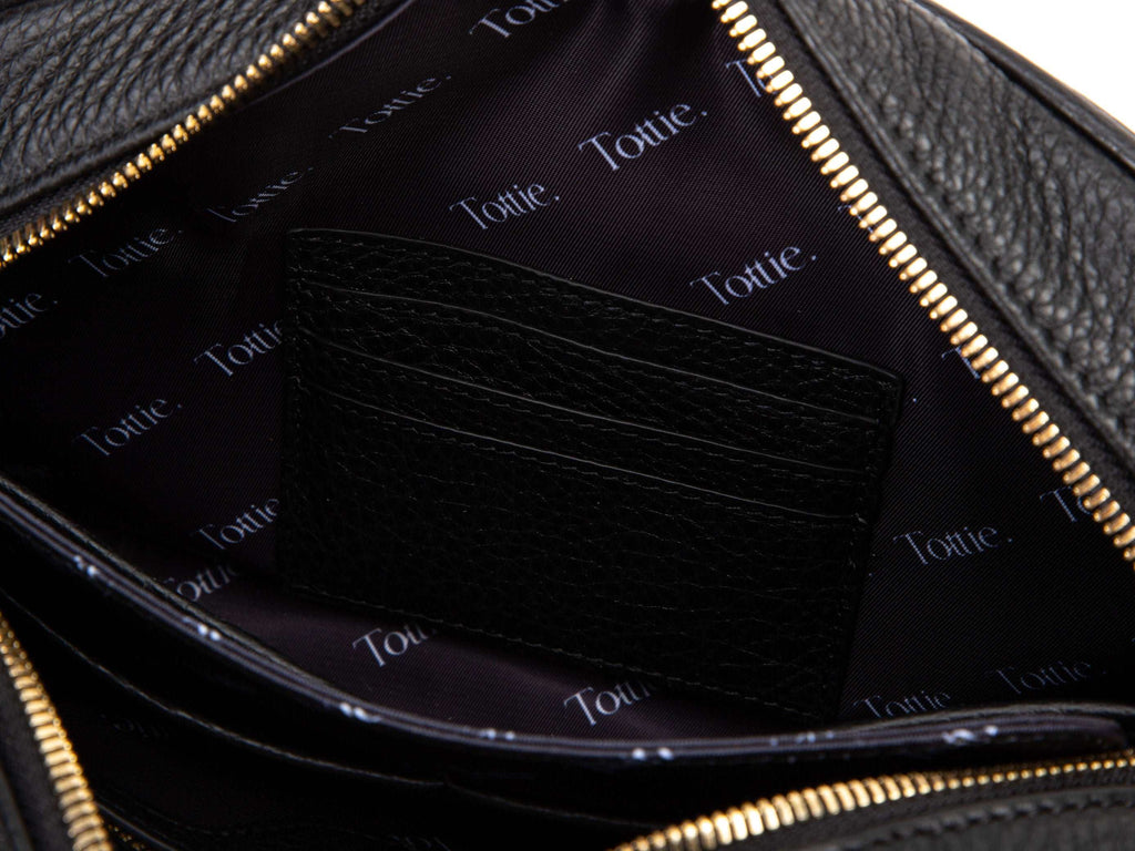 unzipped black leather crossbody bag with gold hardware