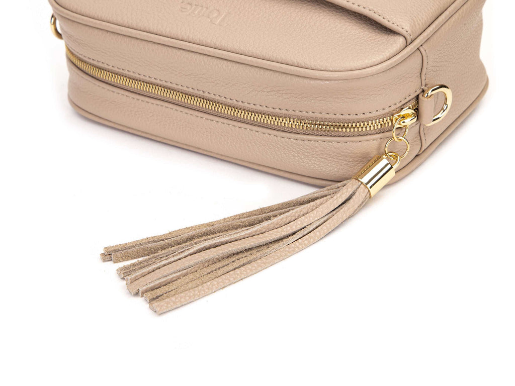 stone colored leather crossbody bag in white background