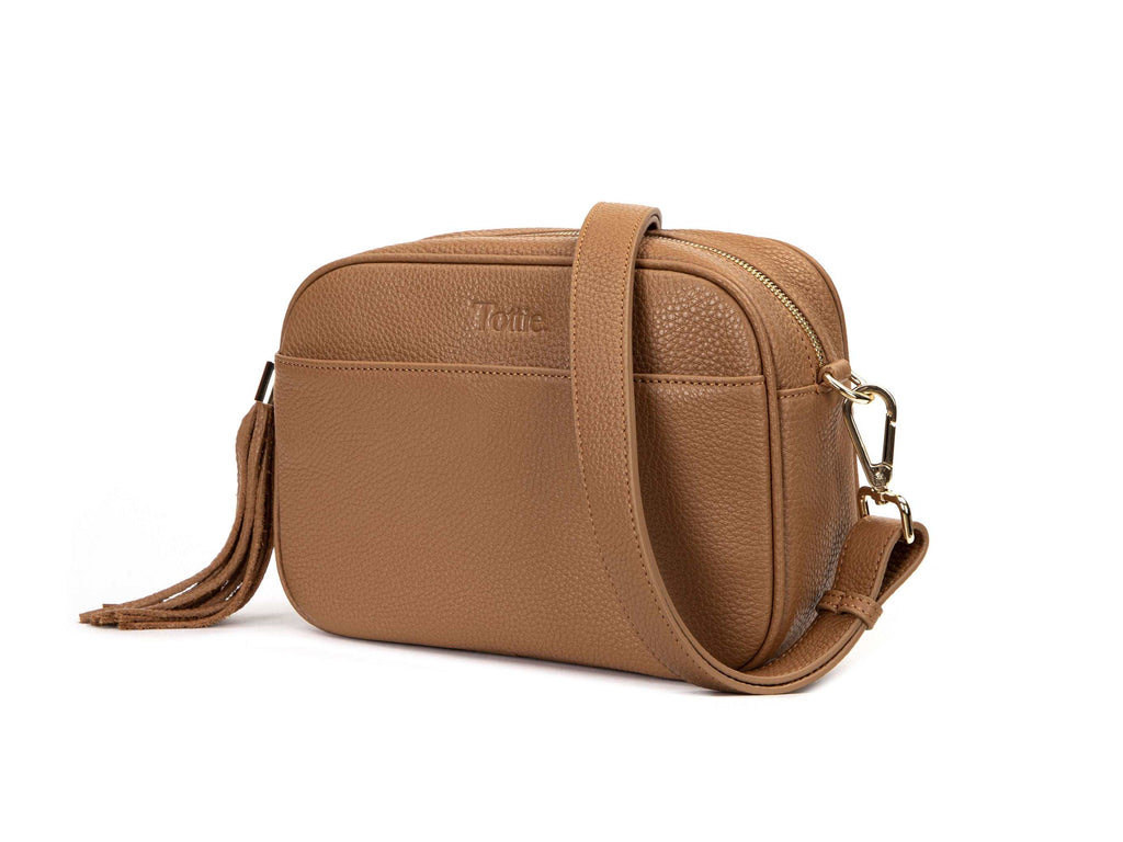 tan colored leather crossbody bag in white background