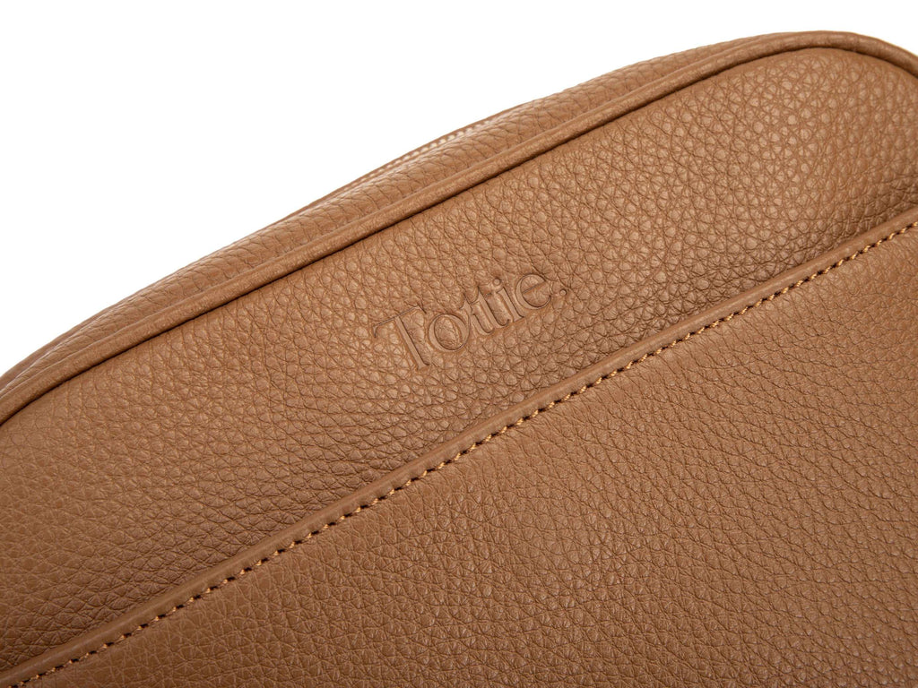 tan colored leather bag in white background