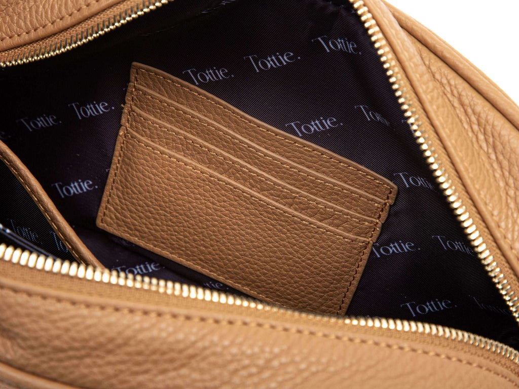 unzipped tan colored leather crossbody bag