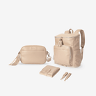 Set of beige nappy bags including a diaper backpack, crossbody bag, change mat, and pair of pram clips on a white background