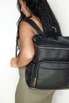 A woman carrying black travel backpack