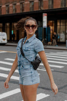 A woman on the street posing and carrying a bum bag